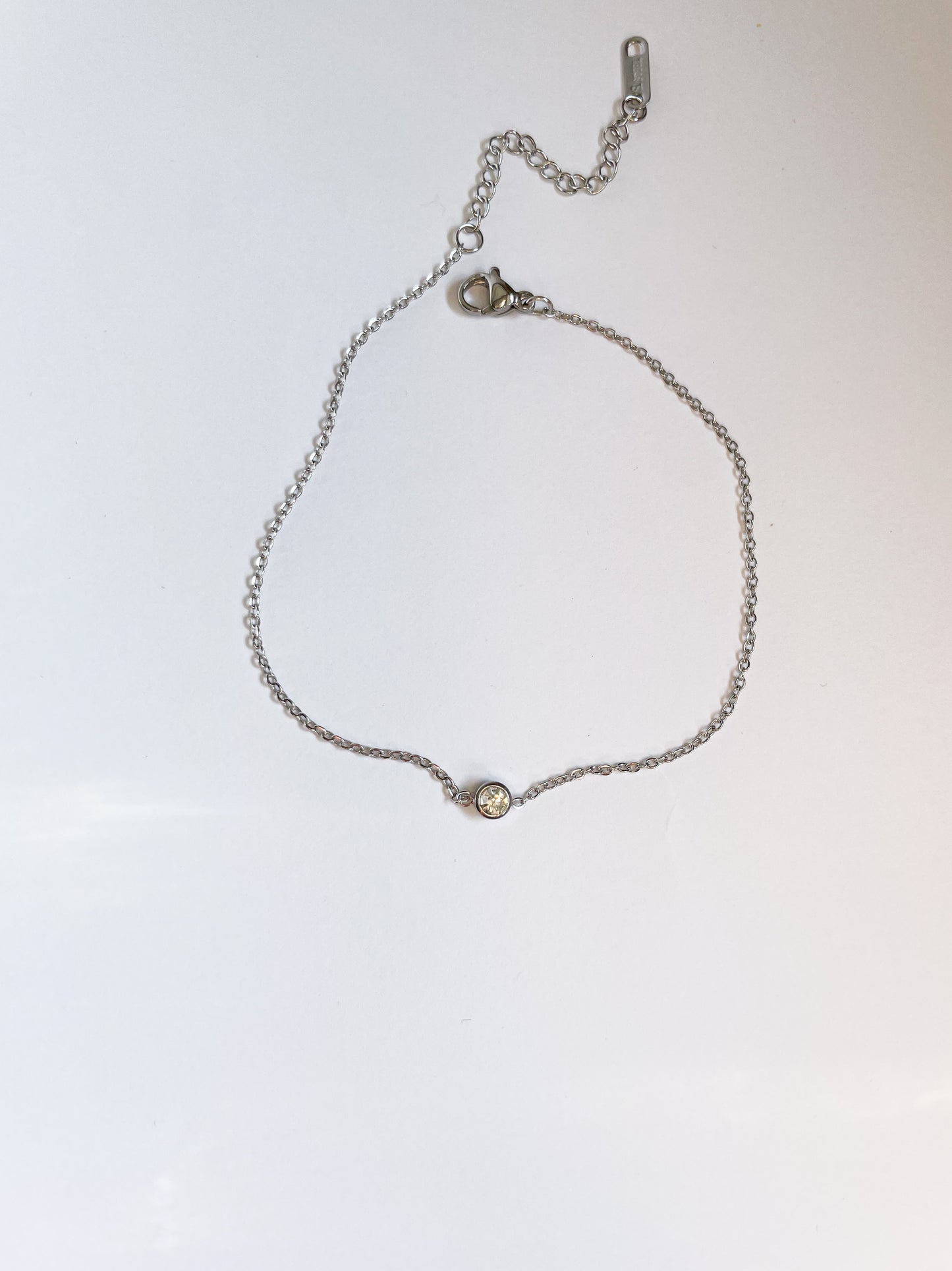 Тънка гривна с малко бяло камъче от медицинска стомана 316L