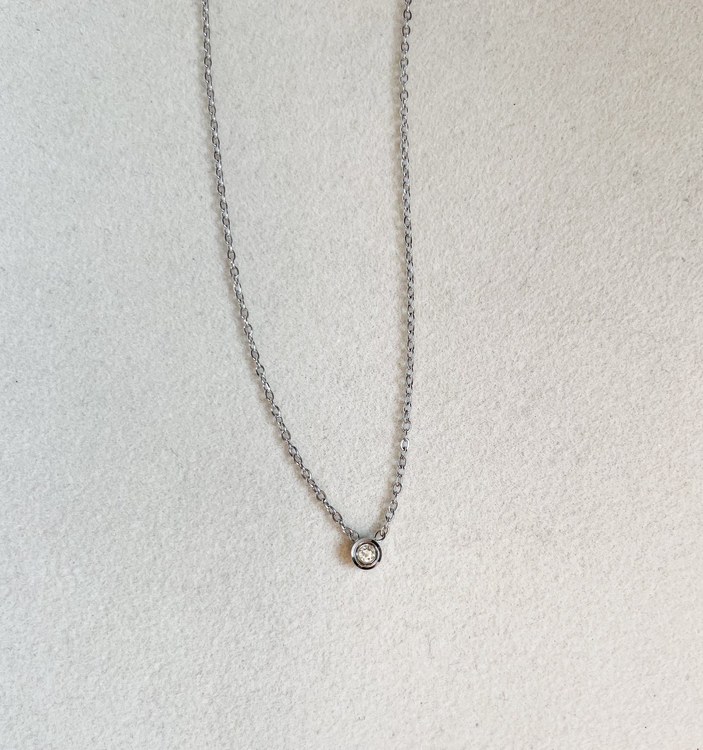 Късо колие с малък бял камък от медицинска стомана в сребрист цвят