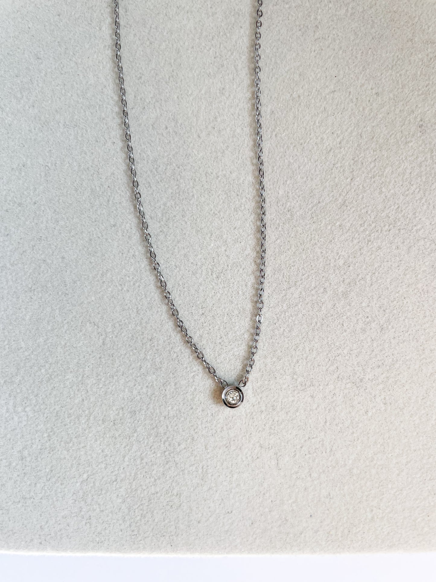 Късо колие с малък бял камък от медицинска стомана в сребрист цвят