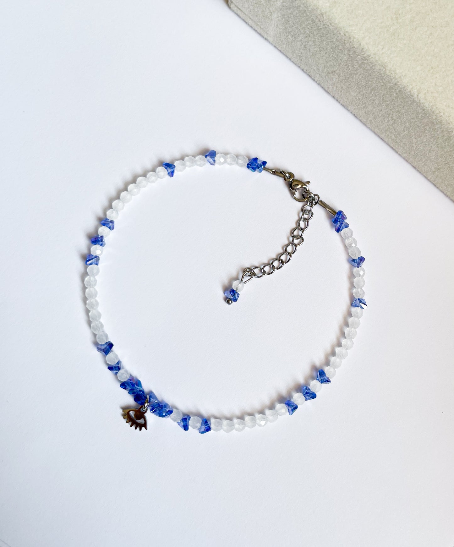 Гривна за глезен със сини и бели кристали и висулка око