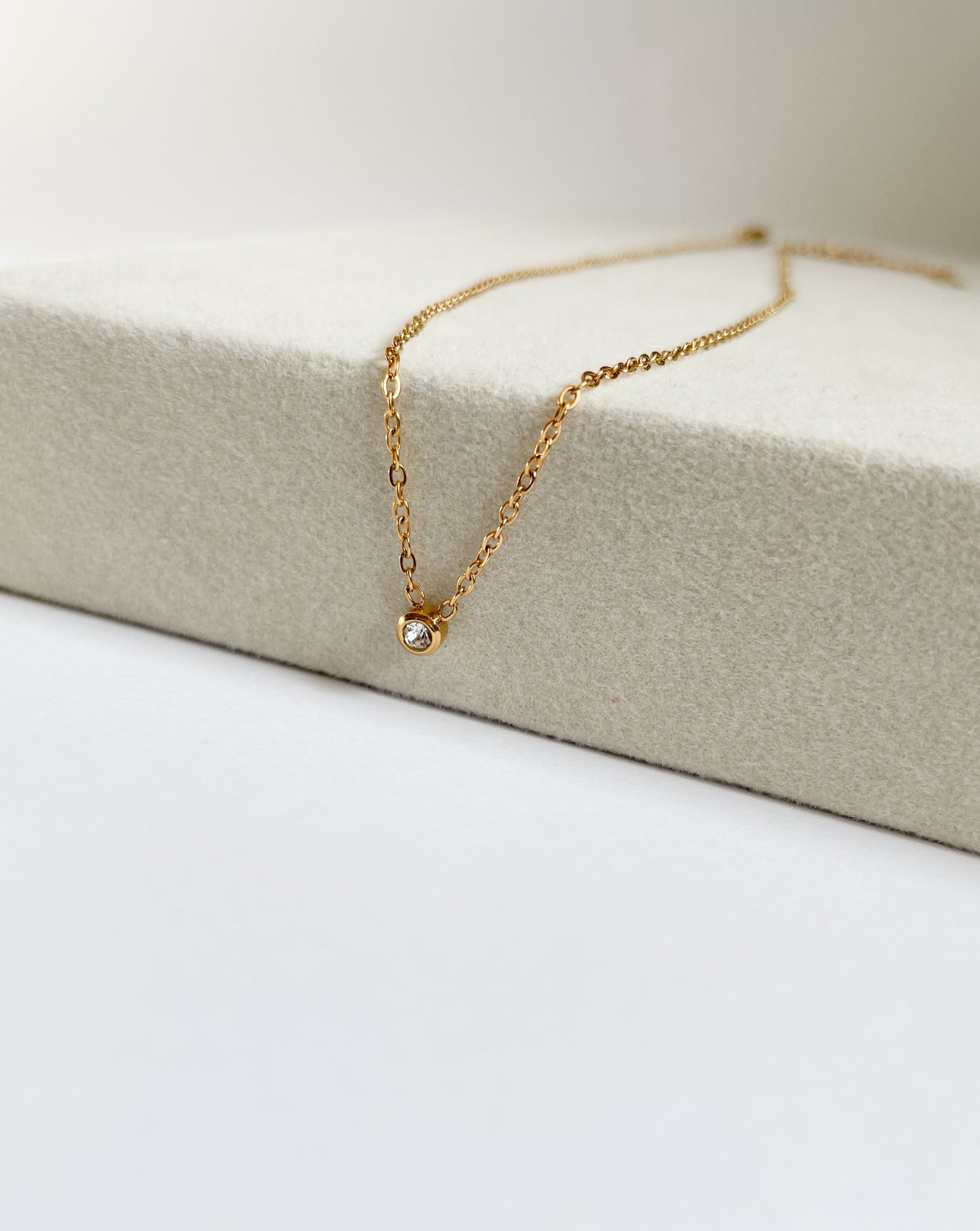 Късо колие с малък бял камък от медицинска стомана