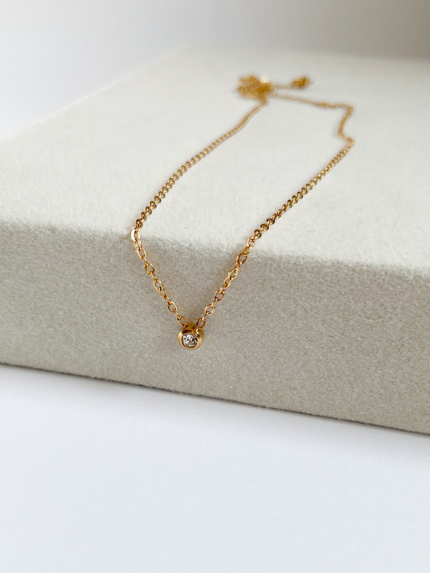 Късо колие с малък бял камък от медицинска стомана